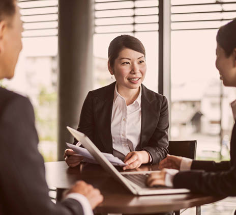 Three Japanese businesspeople in a meeting with a laptop