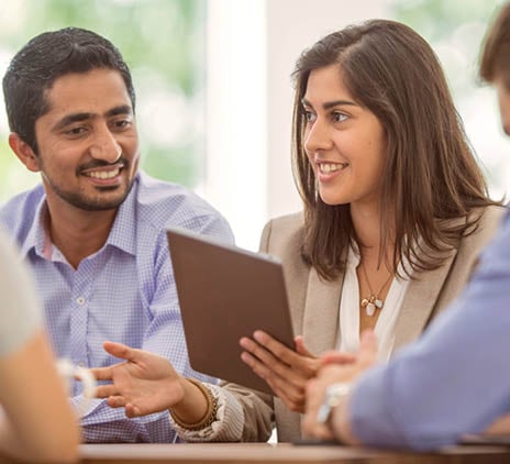 Photo of a team sharing ideas and holding a tablet